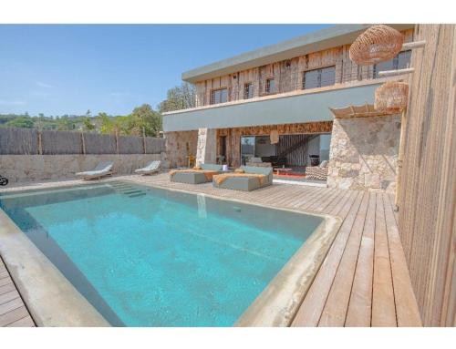 une grande piscine devant une maison dans l'établissement NOUVEAUTE! Magnifique villa à 2 minutes des plus belles plages de la rive sud, à Porticcio