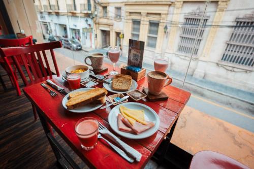 a red table with plates of food and drinks on it at RentUp Suites Salta in Salta