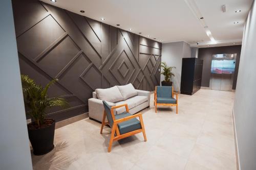 a living room with a couch and two chairs at RentUp Suites Salta in Salta
