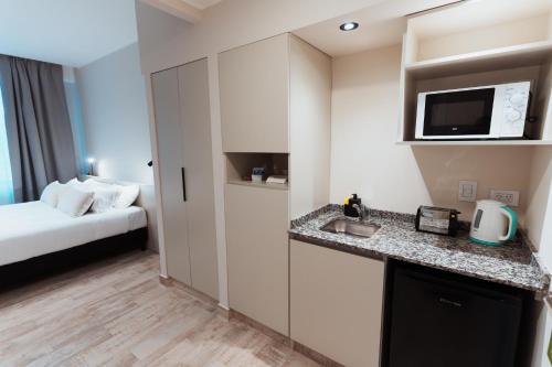 a hotel room with a bed and a kitchen at RentUp Suites Salta in Salta