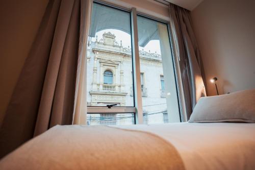 a bedroom with a window with a view of a building at RentUp Suites Salta in Salta