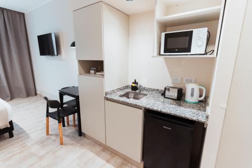 a room with a kitchen with a sink and a microwave at RentUp Suites Salta in Salta