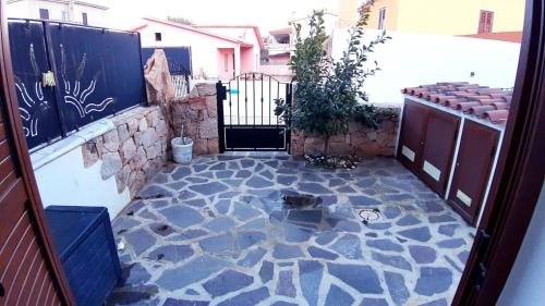 a courtyard with a stone floor and a gate at P I G Ó 's HOUSE in Budoni