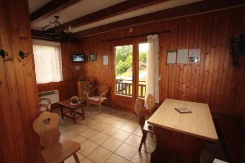 a room with a table and chairs and a balcony at Charmant petit chalet cosy in Combloux