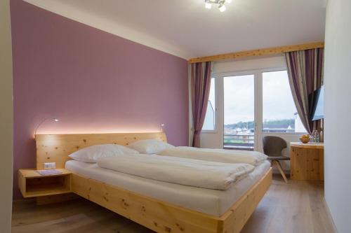 a bedroom with a large bed and a large window at Gasthof Zur Traube in Grein