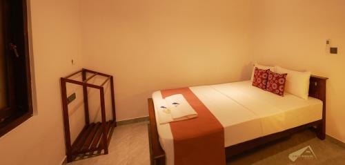 a small bedroom with a bed and a mirror at D Plus Homestay Negombo in Negombo