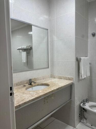 a white bathroom with a sink and a mirror at City Hotel- Mercado Publico, Prefeitura Municipal in Porto Alegre