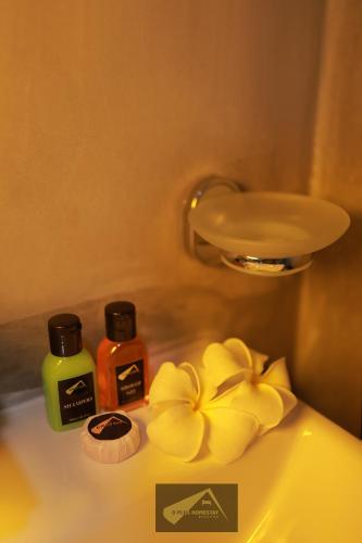 a bathroom with two bottles of soap and a flower at D Plus Homestay Negombo in Negombo
