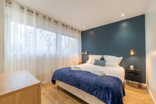 une chambre avec un lit et une grande fenêtre dans l'établissement Appartement Sacré Cœur - Cottages 1, à Paris