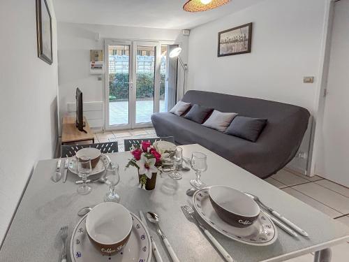 a living room with a table and a couch at Grande terrasse privée à 5min de la Plage à pied in Villers-sur-Mer