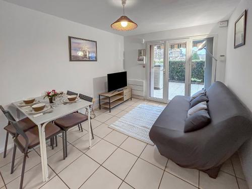 a living room with a couch and a table at Grande terrasse privée à 5min de la Plage à pied in Villers-sur-Mer