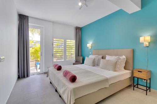 a bedroom with a large bed with red pillows on it at Delfins Residences in Kralendijk