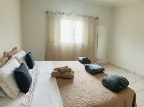 a bedroom with a large bed with two pillows on it at Suite Delfinopolis in Delfinópolis