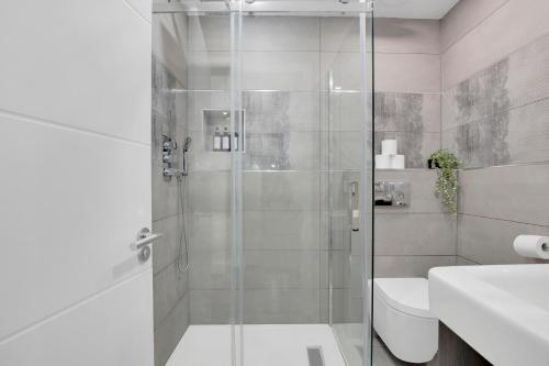 a bathroom with a shower with a toilet and a sink at Skyline Studios Tower Bridge in London