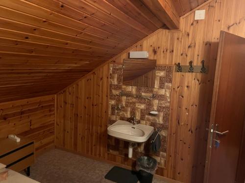 un bagno con lavandino in una parete di legno di Zimmervermietung Ackersand a Stalden