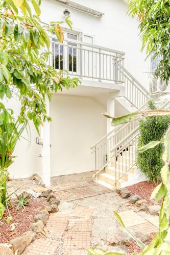 a white house with a staircase in front of it at Kaz Trou d Eau in Saint-Paul