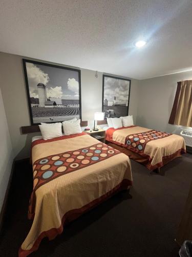 a hotel room with two beds and two pictures on the wall at Super 8 by Wyndham Blair in Blair
