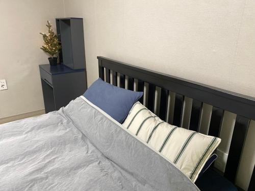 a bed with a blue pillow on top of it at 스테이 휴가 의정부점 in Uijeongbu