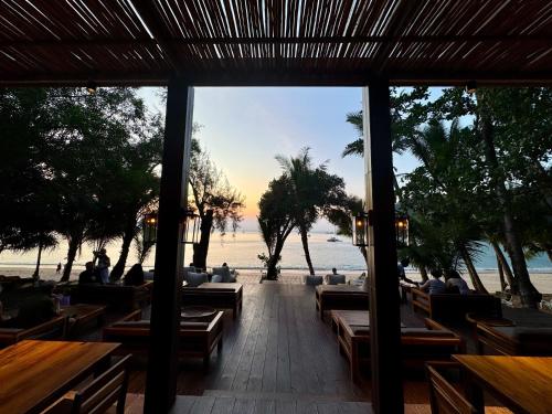 a restaurant on the beach with a view of the ocean at Sunny Cove Beach Resort Koh Phayam in Ranong