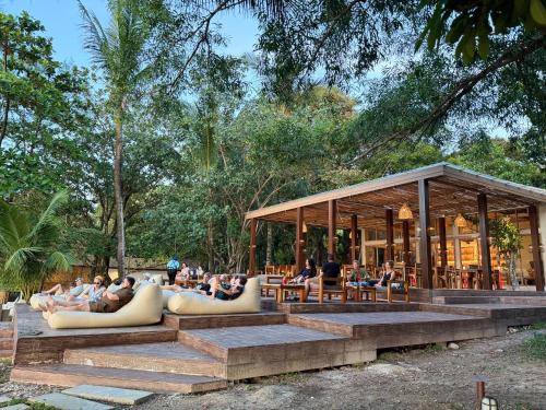 a pavilion with people sitting on couches and chairs at Sunny Cove Beach Resort Koh Phayam in Ranong