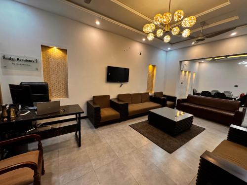 a living room with couches and a flat screen tv at Bridge Residency-2 Top City-1 Islamabad in Islamabad