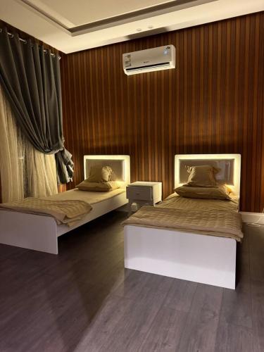two beds in a room with wooden walls at شقة الحياة 1 in Medina