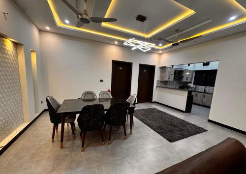 a dining room with a table and chairs and a kitchen at Bridge Residency-2 Top City-1 Islamabad in Islamabad