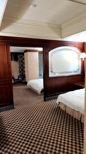 a hotel room with two beds and a mirror at 爵起商務飯店 in Taoyuan