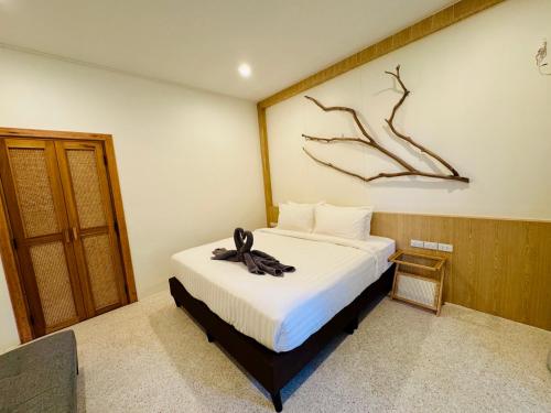 a bedroom with a bed with a black ribbon on it at Sunny Cove Beach Resort Koh Phayam in Ranong