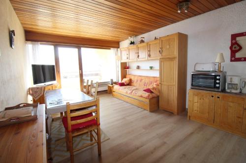 - un salon avec une table et une chambre avec un canapé dans l'établissement Au petit Huez, à Auris