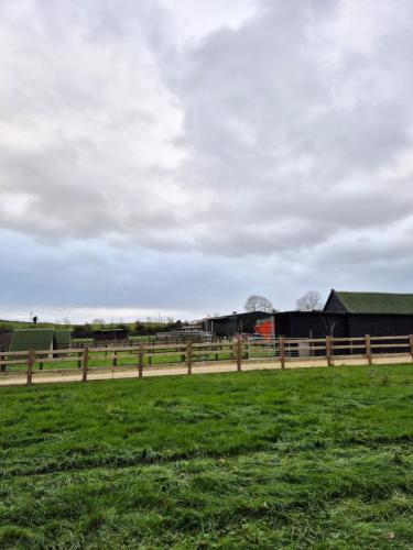 a farm with a fence and a green field at The Cranny, 1 Bedroom House with Indoor Fireplace in Bicester