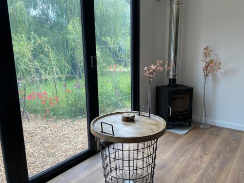 a room with a table in front of a window at The Cranny, 1 Bedroom House with Indoor Fireplace in Bicester
