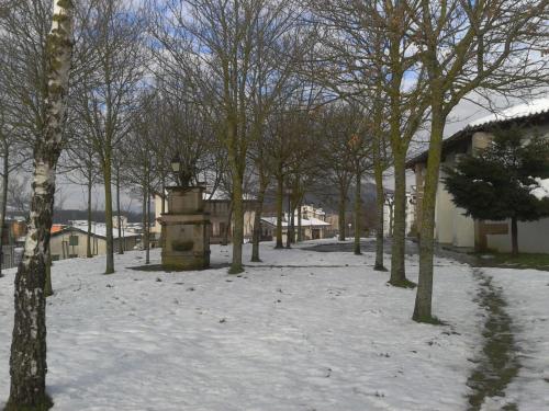a park covered in snow with trees and buildings at Apartamento Rural Arluzepe in Echarri-Aranaz