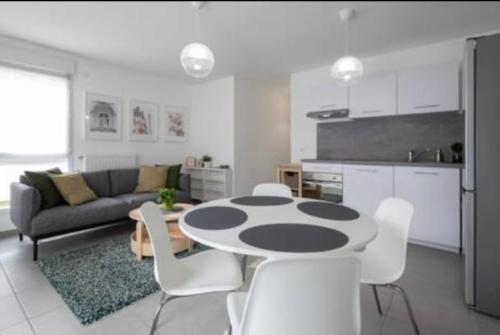 une cuisine et un salon avec une table et des chaises dans l'établissement Appartement cocon, à Décines-Charpieu