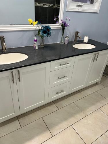 a bathroom with two sinks and a black counter at SHAY 2ND FLOOR-Holiday Home in Pickering