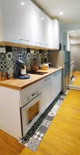 une cuisine avec des armoires blanches et un four à plaques de cuisson dans l'établissement 3 chambres 100m plage, à Berck-sur-Mer