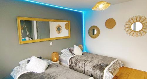 Cette chambre comprend 2 lits et un miroir mural. dans l'établissement 3 chambres 100m plage, à Berck-sur-Mer