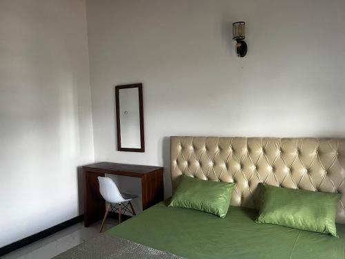 a bedroom with a bed and a chair and a mirror at Transit Terminal at colombo airport in Katunayake