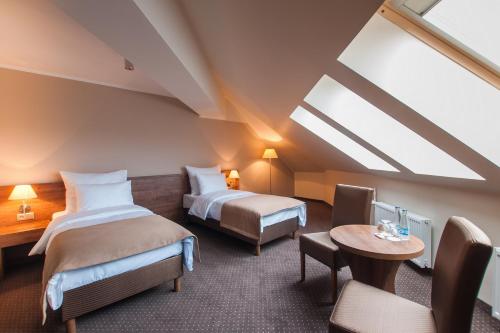 a hotel room with two beds and a table at Hotel Gem in Wrocław
