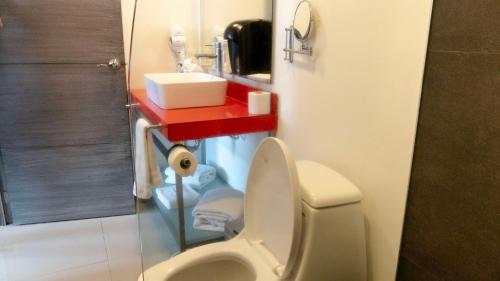 a bathroom with a toilet and a red shelf at Hotel Black Boutique in Mexico City