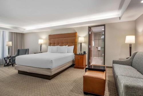 a hotel room with a bed and a couch at Drury Inn & Suites Atlanta Airport in Atlanta