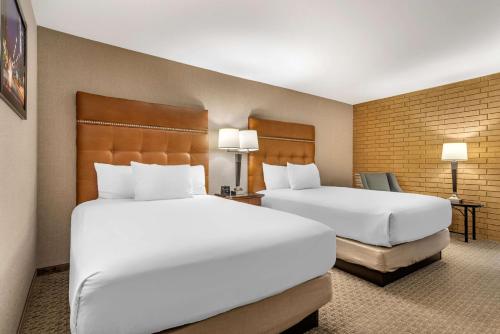 two beds in a hotel room with white pillows at Drury Inn & Suites Atlanta Airport in Atlanta