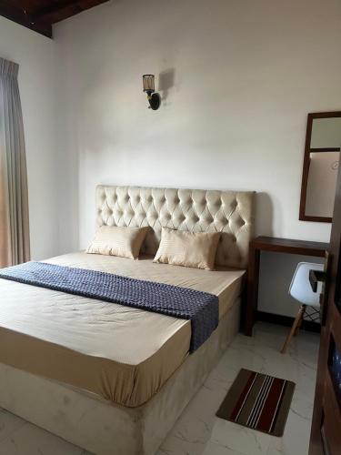 a bedroom with a large bed with a tufted headboard at Transit Terminal at colombo airport in Katunayake
