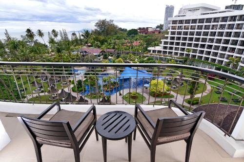 a balcony with a table and chairs and a view of a resort at Shangri-La Golden Sands, Penang in Batu Ferringhi