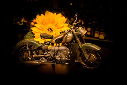a motorcycle parked on a table with a yellow flower at Hotel Bigger Hof - Wirtshaus Platzhirsch am Jahnplatz in Olsberg