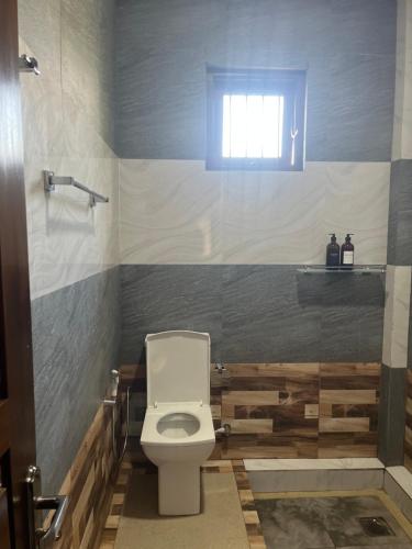 a bathroom with a toilet and a shower and a window at Transit Terminal at colombo airport in Katunayake