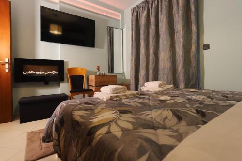 a bedroom with a bed with a fireplace and a tv at City center apartment in Nafpaktos