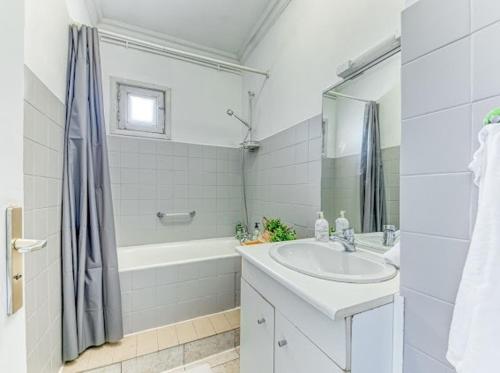 une salle de bain avec un lavabo, une baignoire et une douche dans l'établissement Elegant Zola, à Villeurbanne