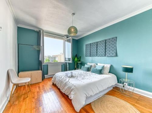 une chambre avec un grand lit aux murs bleus dans l'établissement Elegant Zola, à Villeurbanne