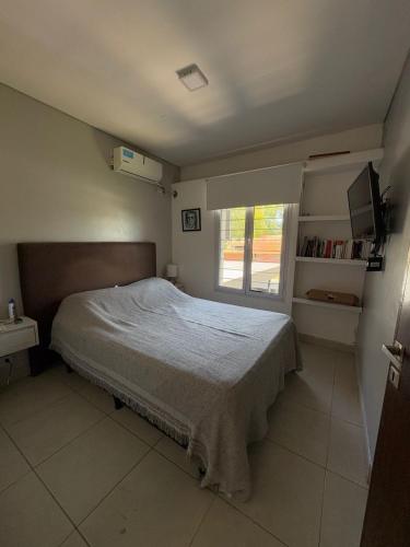 una camera da letto con un letto grande con una finestra di Casa ALI, cuenta con 4 camas individuales y una cama matrimonial, capacidad máxima 6 personas a Yerba Buena